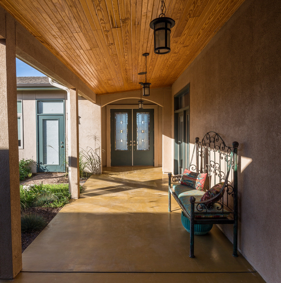 Southwest concrete porch photo in Dallas with a roof extension