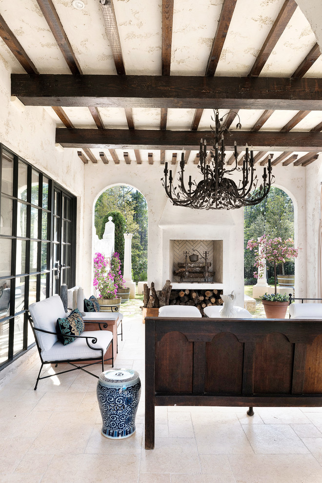 Idée de décoration pour un grand porche d'entrée de maison arrière méditerranéen avec un foyer extérieur.