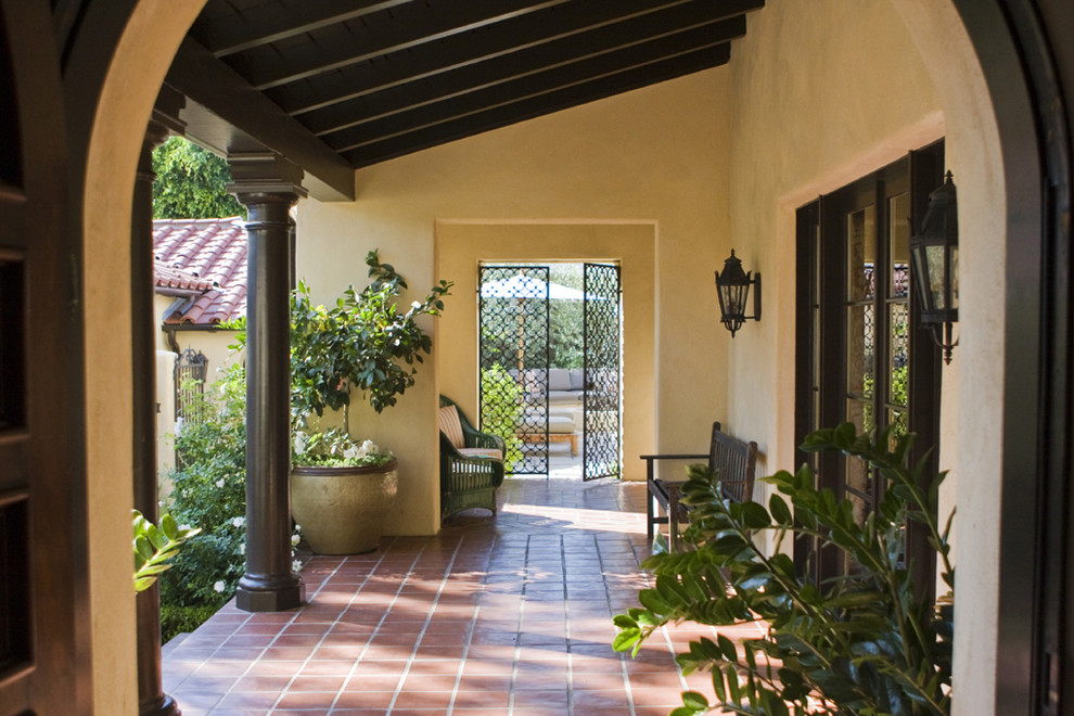 Foto de terraza mediterránea en anexo de casas y patio delantero con suelo de baldosas y jardín de macetas