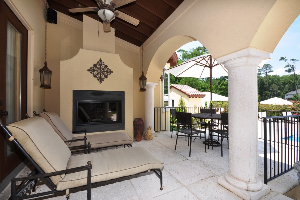 Huge tuscan concrete paver back porch photo in Other with a fire pit and a roof extension