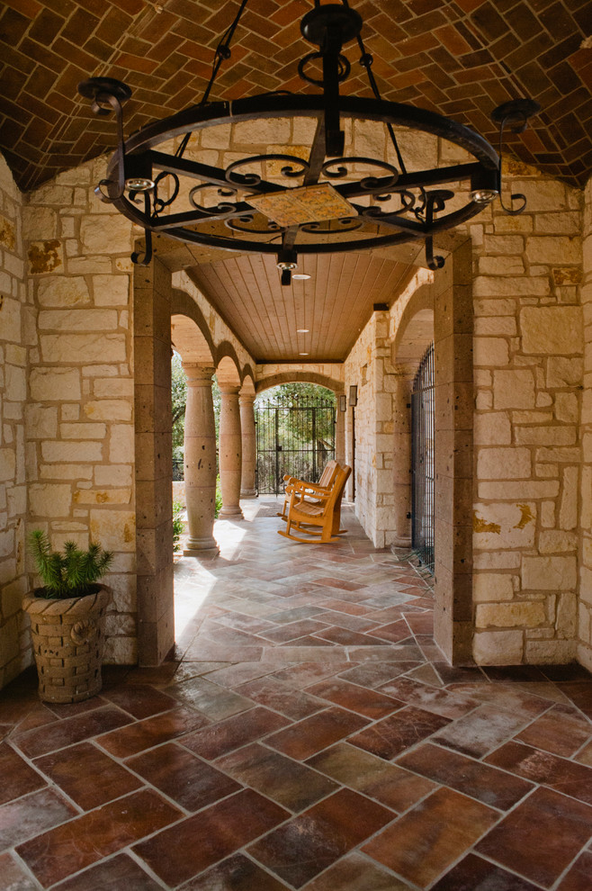 This is an example of a huge southwestern tile front porch design in Austin with a roof extension.