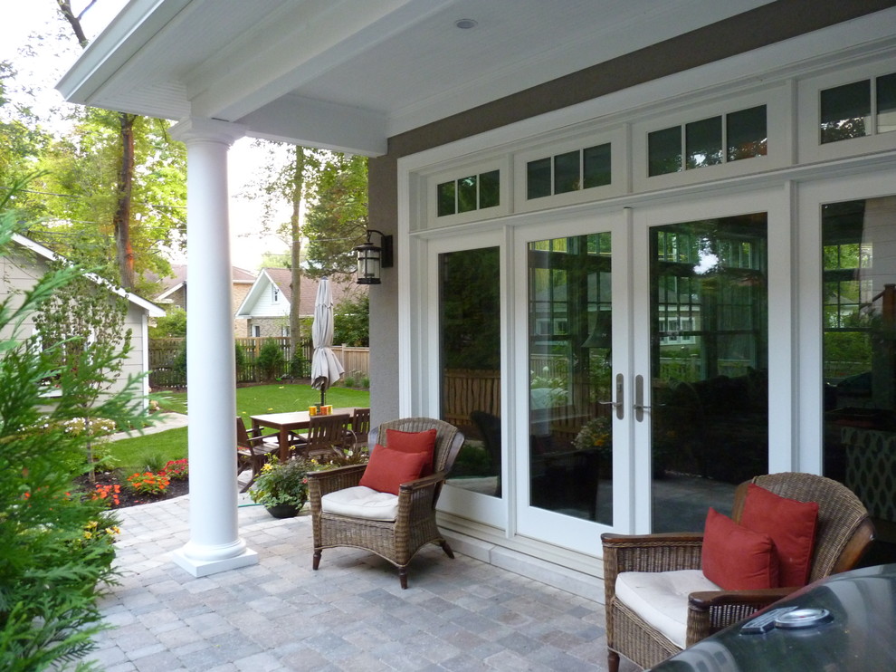 Diseño de terraza en patio lateral y anexo de casas con cocina exterior y adoquines de piedra natural