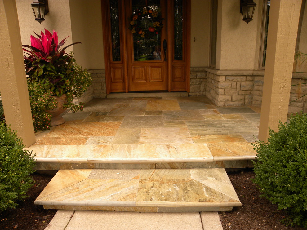 Design ideas for a traditional front veranda in Chicago with a potted garden and natural stone paving.