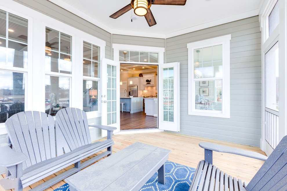 This is an example of a large beach style back screened veranda in Other with a roof extension.