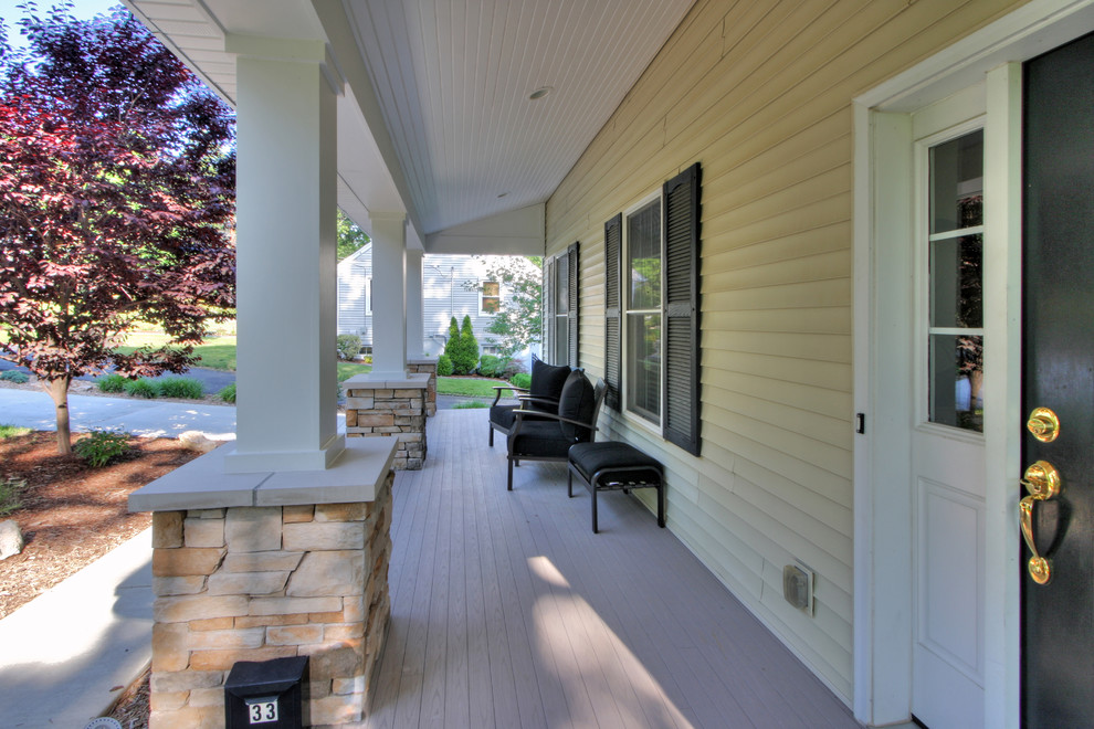 Cette image montre un porche d'entrée de maison avant design de taille moyenne avec une terrasse en bois et une extension de toiture.