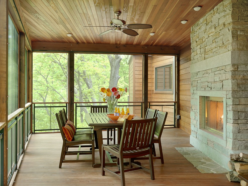 Farmhouse porch photo in St Louis with a fire pit and a roof extension