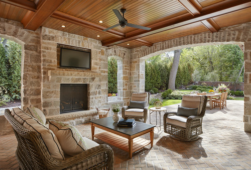 outdoor patio featuring stone walls and brick flooring