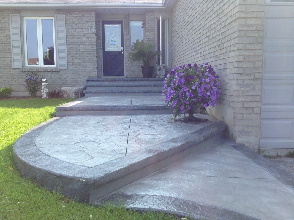 This is an example of a medium sized classic front veranda in Toronto with stamped concrete.