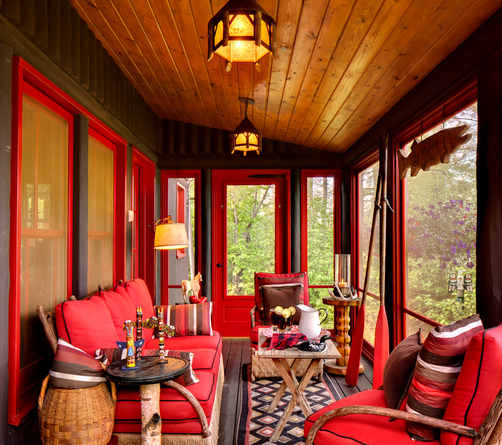 Aménagement d'un porche d'entrée de maison montagne avec une moustiquaire et une terrasse en bois.
