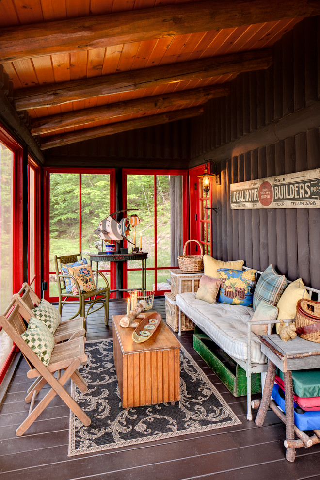 Exemple d'un porche d'entrée de maison montagne avec une moustiquaire et une terrasse en bois.