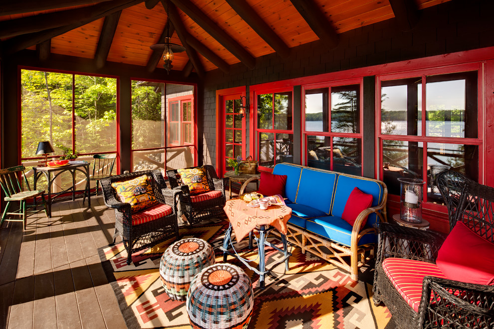 Cette image montre un porche d'entrée de maison chalet avec une moustiquaire et une terrasse en bois.