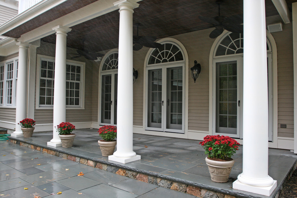 Inspiration för en vintage veranda på baksidan av huset, med naturstensplattor och takförlängning