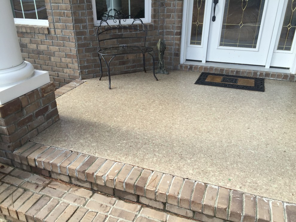 This is an example of a small classic front veranda in Other with concrete slabs.