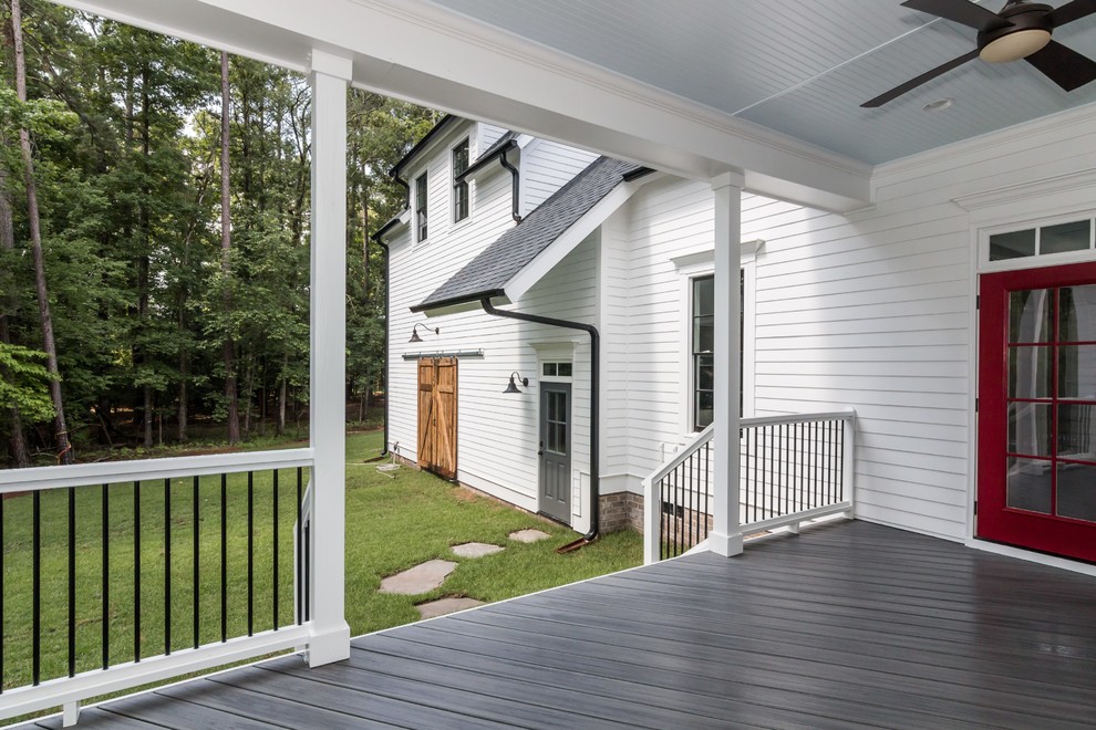 Idées déco pour un grand porche d'entrée de maison arrière campagne avec une terrasse en bois et une extension de toiture.
