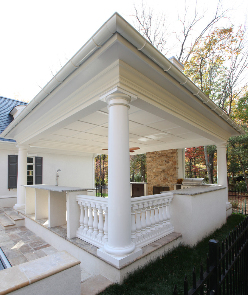 Cette photo montre un très grand porche d'entrée de maison latéral chic avec une cuisine d'été et des pavés en pierre naturelle.