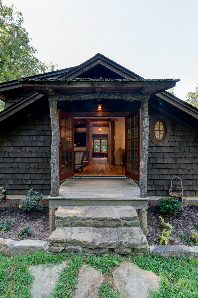 Idée de décoration pour un porche d'entrée de maison latéral chalet de taille moyenne avec une terrasse en bois et une extension de toiture.