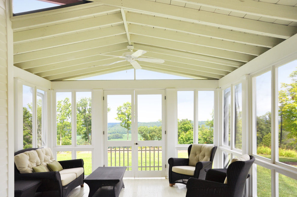 Idée de décoration pour un porche d'entrée de maison champêtre avec une terrasse en bois, une extension de toiture et une moustiquaire.