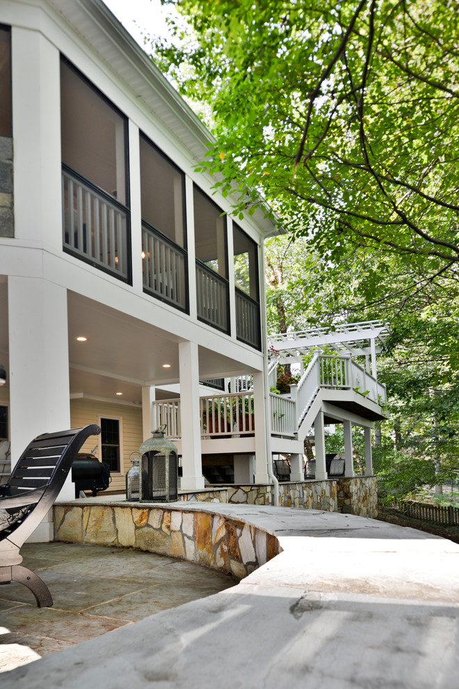 This is an example of a huge modern screened-in back porch design in DC Metro with a pergola.