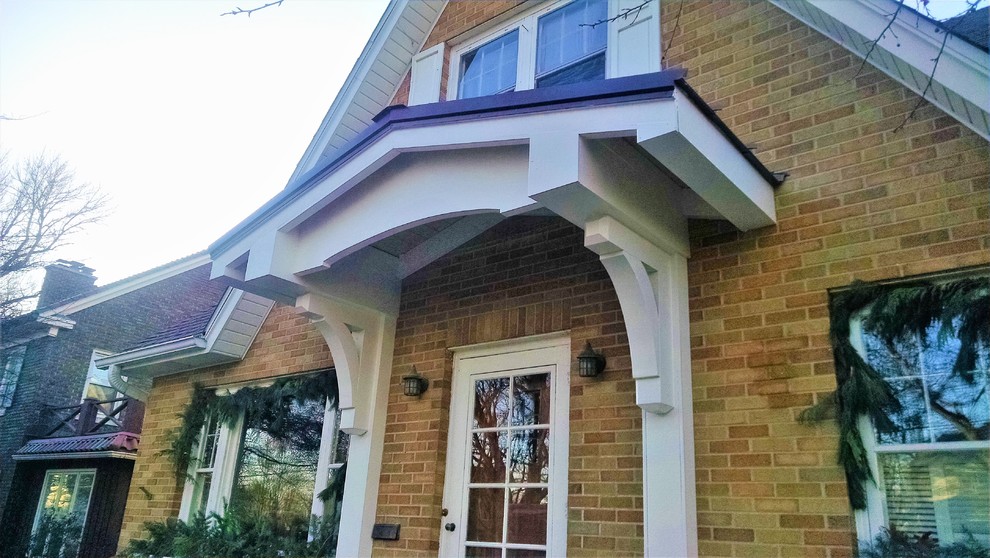 Idée de décoration pour un porche d'entrée de maison avant tradition de taille moyenne avec une dalle de béton et un auvent.