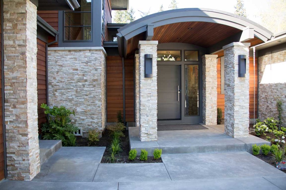 Idée de décoration pour un porche d'entrée de maison avant design de taille moyenne avec une extension de toiture et une dalle de béton.