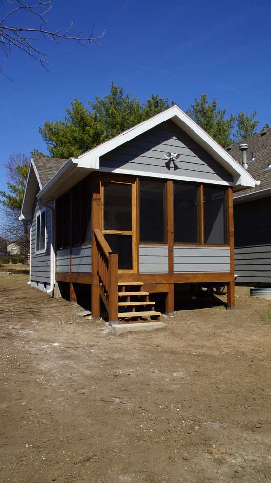 Imagen de porche cerrado tradicional de tamaño medio en patio trasero y anexo de casas con entablado