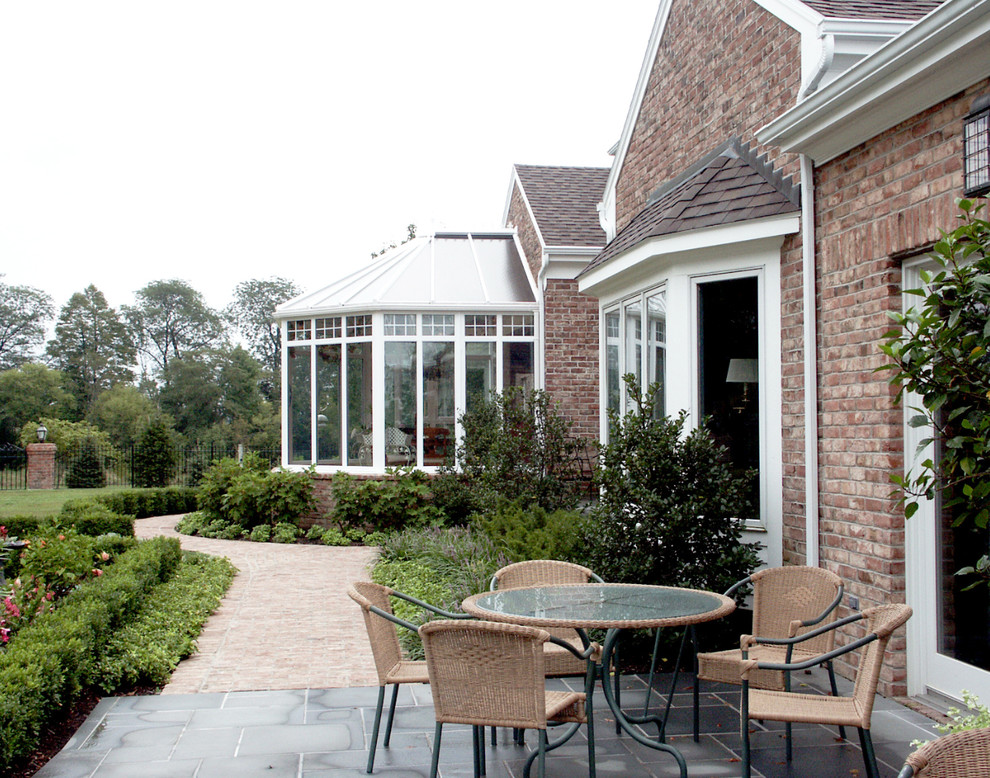 This is an example of a large traditional back veranda in New York with a roof extension.