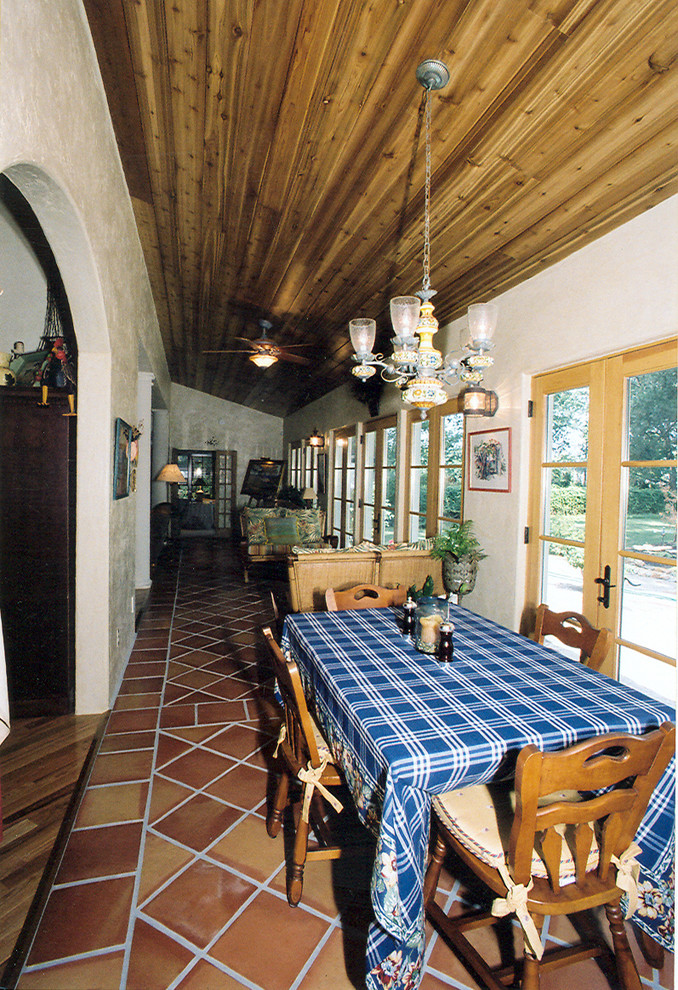 Cette image montre un porche d'entrée de maison arrière méditerranéen de taille moyenne avec du carrelage et une extension de toiture.