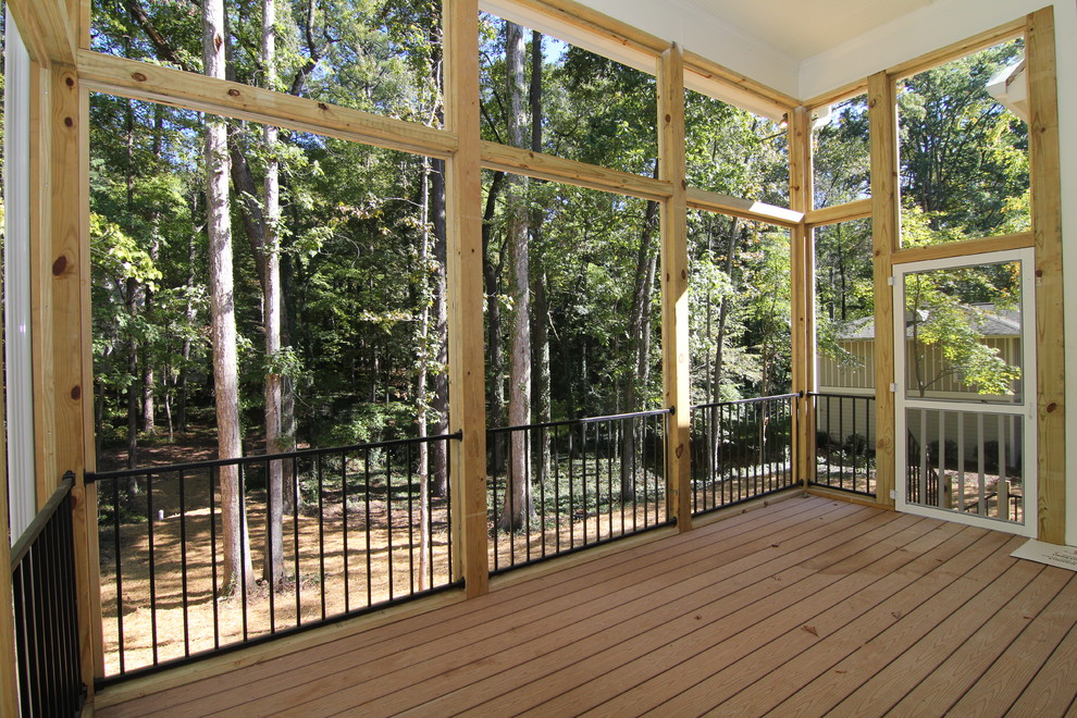 This is an example of a large classic back screened veranda in Raleigh with decking and a roof extension.