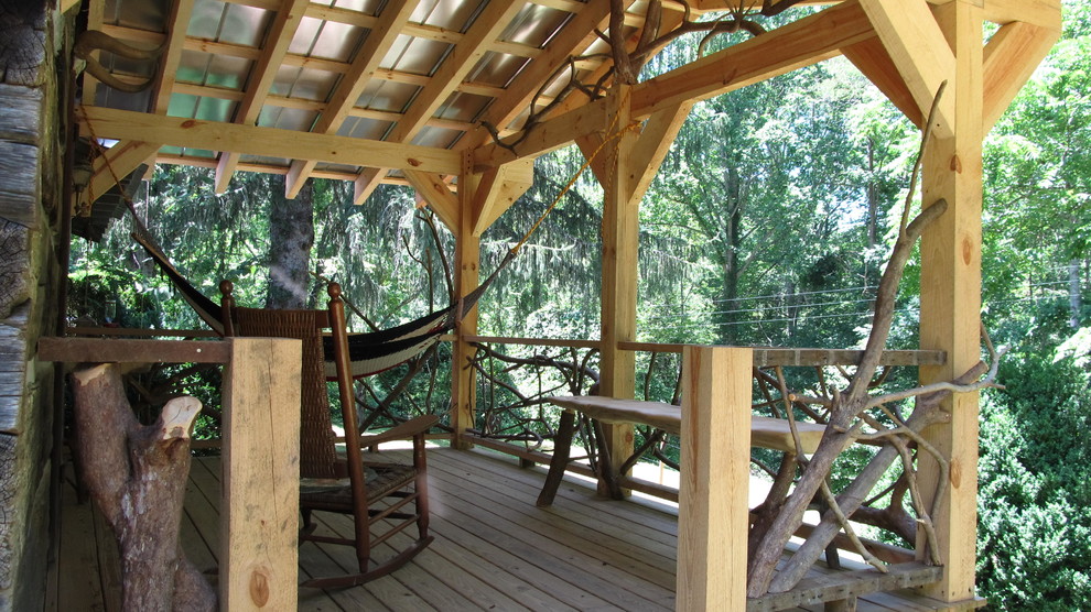 Cette image montre un porche d'entrée de maison chalet avec une terrasse en bois et une extension de toiture.