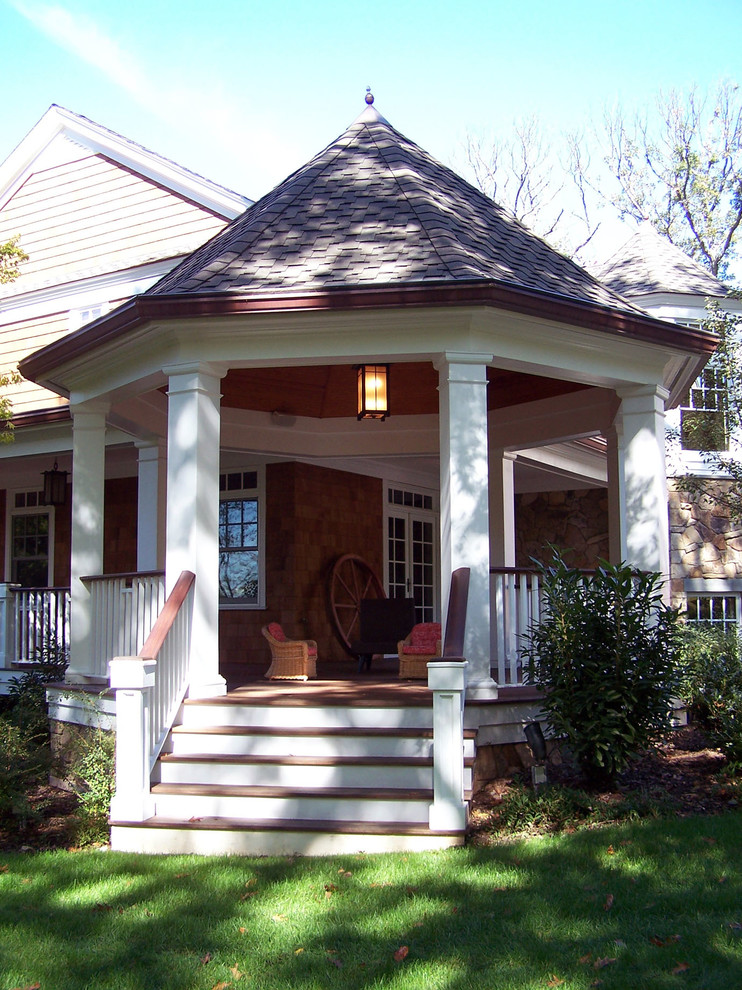 Idées déco pour un grand porche d'entrée de maison arrière campagne avec une terrasse en bois.