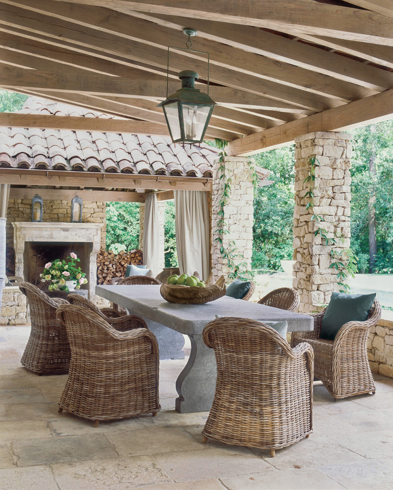 Photo of a large mediterranean back veranda in Houston with a pergola, natural stone paving and feature lighting.