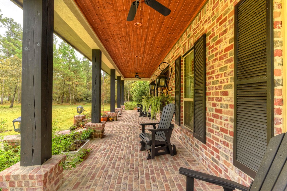 Inspiration for a large eclectic front porch remodel in Houston with an awning