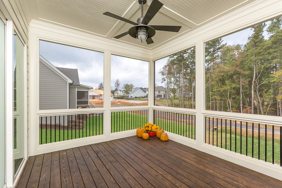 This is an example of a mid-sized cottage screened-in back porch design in Raleigh with decking and a roof extension.