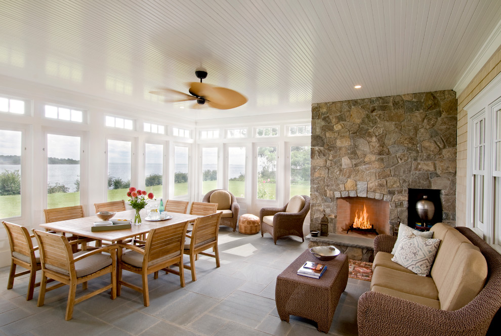 This is an example of a beach style veranda in Boston with a fire feature, a roof extension and all types of cover.
