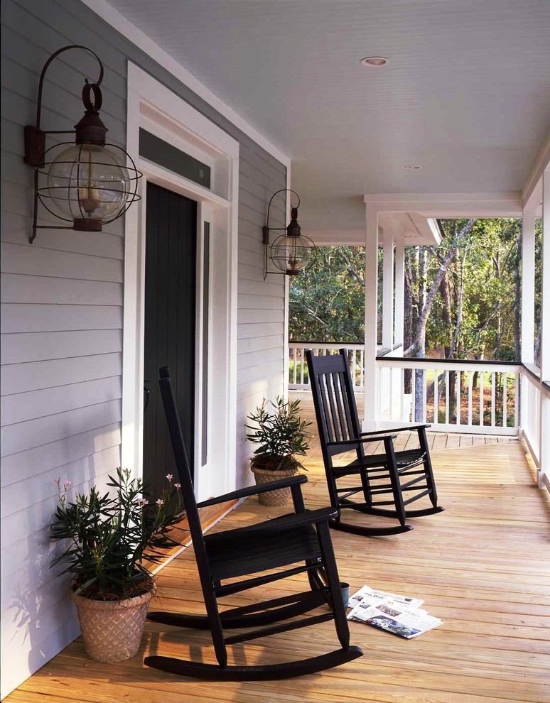 Aménagement d'un grand porche avec des plantes en pot avant classique avec une terrasse en bois et une extension de toiture.