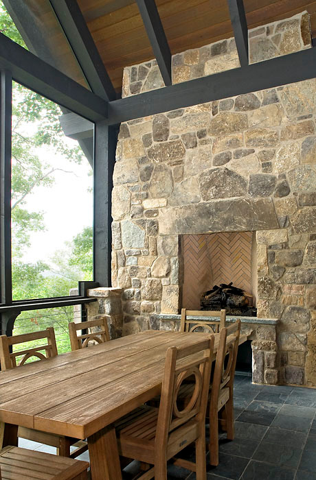 Cette image montre un grand porche d'entrée de maison latéral traditionnel avec une cheminée, du carrelage et une extension de toiture.