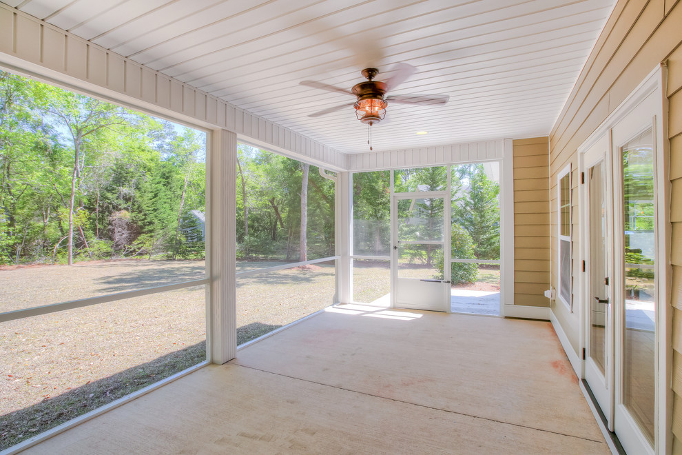 Foto de porche cerrado de estilo americano de tamaño medio en patio trasero y anexo de casas con losas de hormigón
