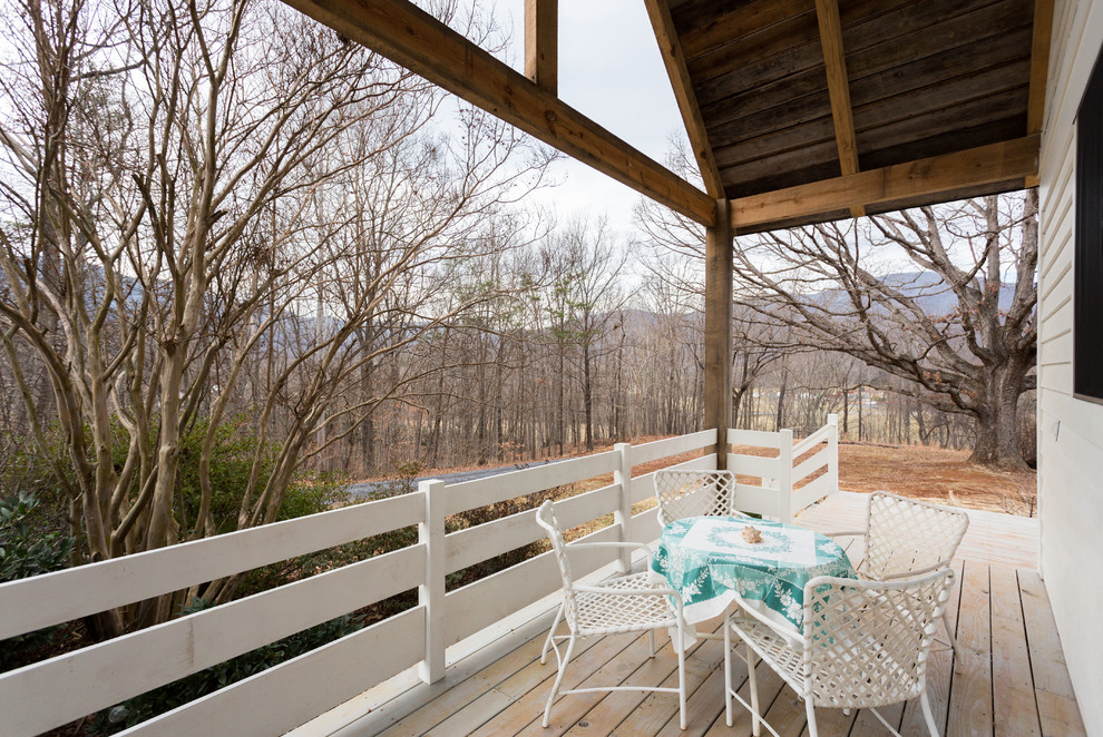 Idées déco pour un porche d'entrée de maison avant campagne de taille moyenne avec une terrasse en bois et une extension de toiture.