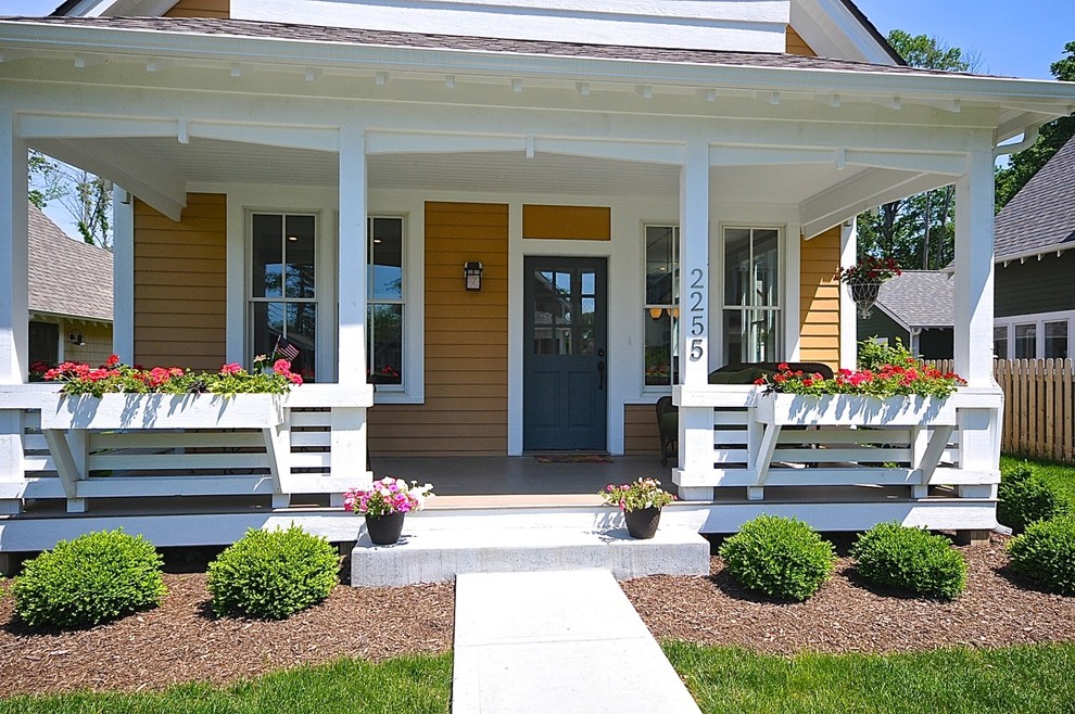 Large elegant front porch photo in Indianapolis with a roof extension