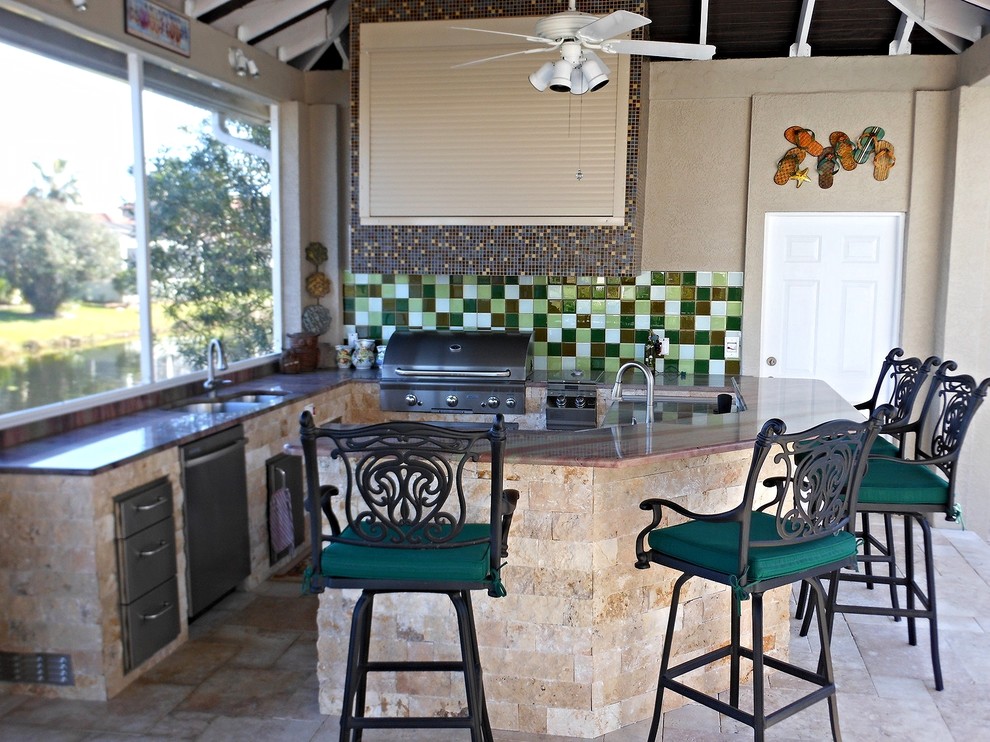 Imagen de terraza de estilo americano de tamaño medio en patio trasero y anexo de casas con cocina exterior y adoquines de piedra natural