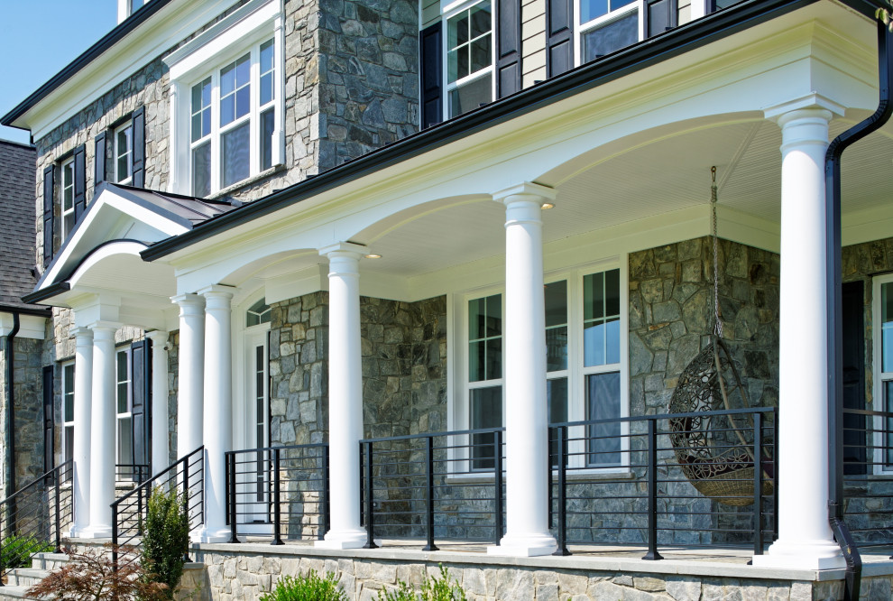 Idee per un ampio portico tradizionale davanti casa con pavimentazioni in pietra naturale, un tetto a sbalzo e parapetto in metallo