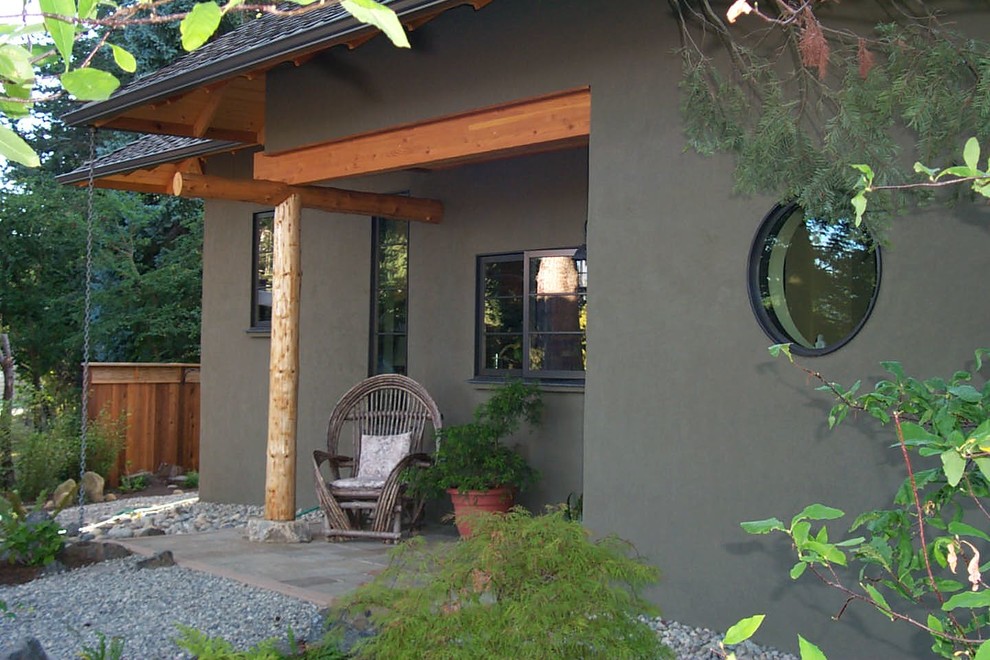 This is an example of a rustic porch design in Seattle with a roof extension.