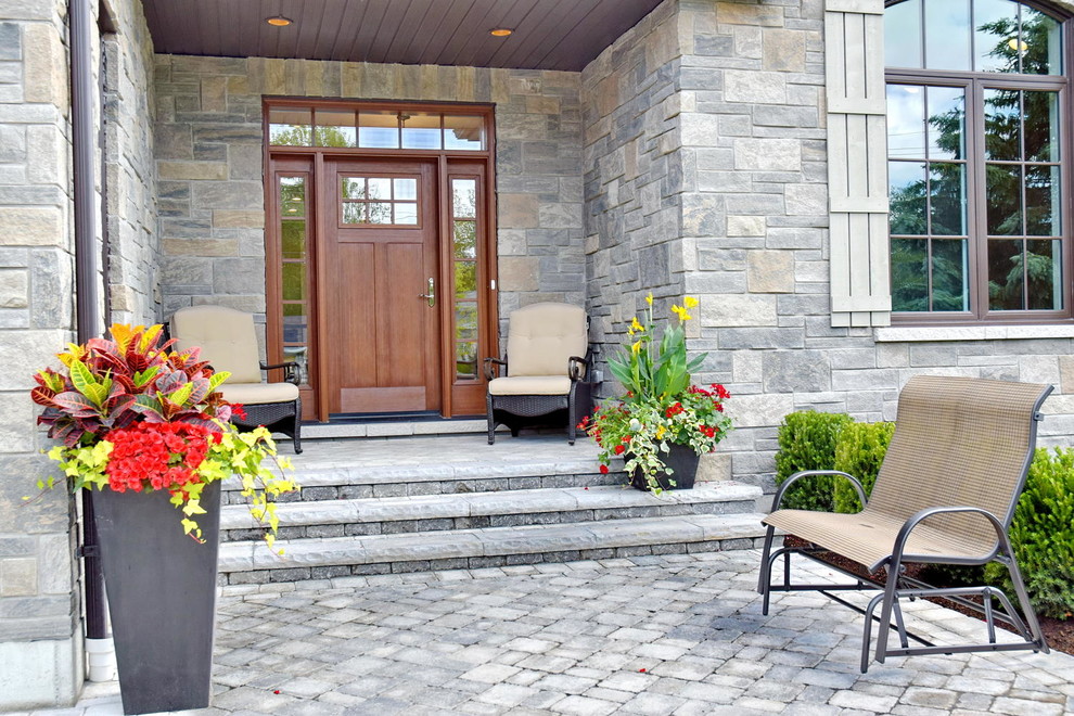 Foto di un portico chic di medie dimensioni e davanti casa con pavimentazioni in cemento e un tetto a sbalzo