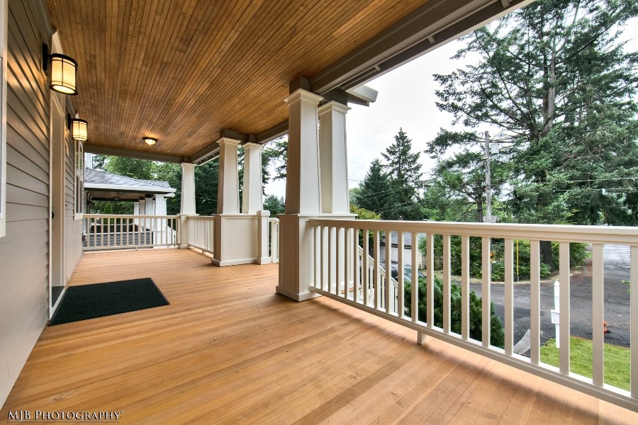 Exemple d'un porche d'entrée de maison avant craftsman avec une terrasse en bois et une extension de toiture.