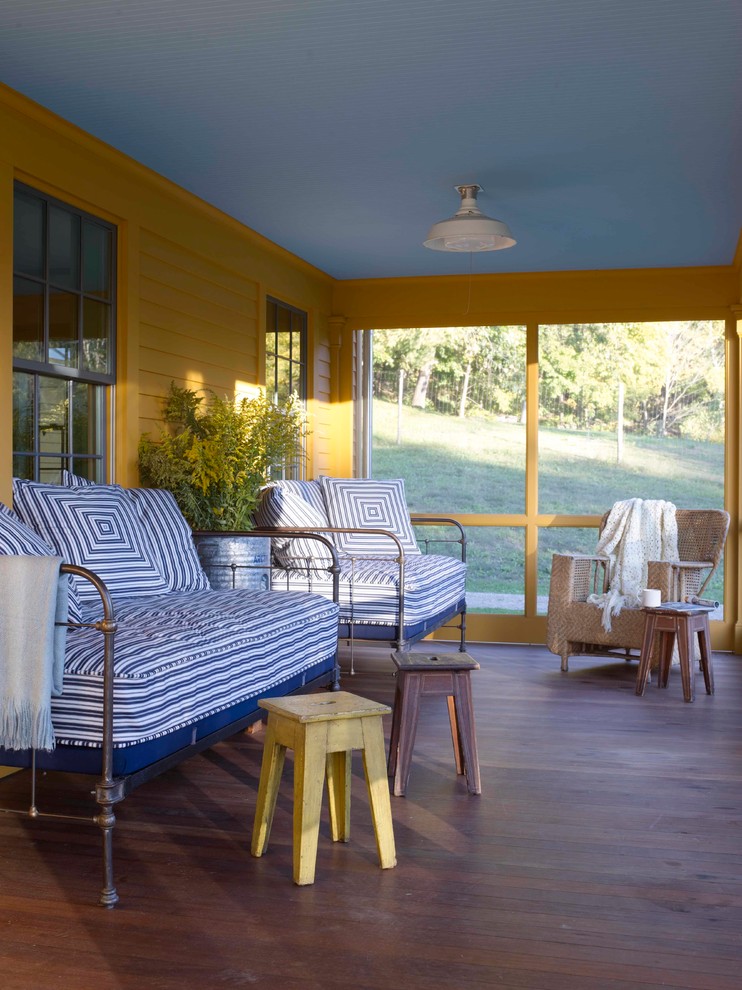 This is an example of a country screened-in front porch design in Bridgeport.