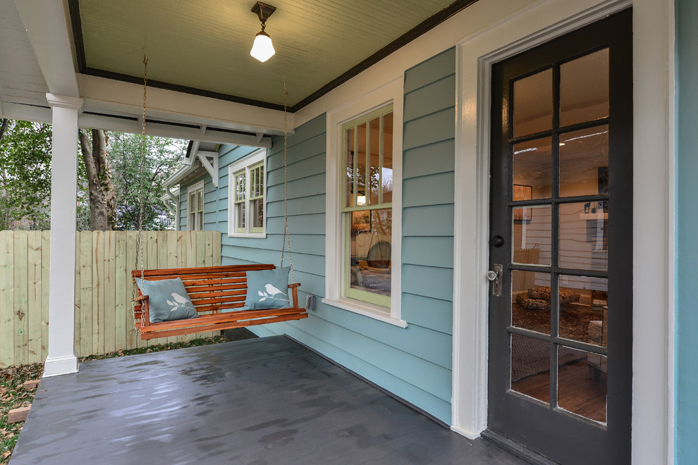 This is an example of a small traditional side porch design in Atlanta with a roof extension.