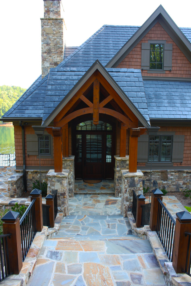 Esempio di un portico stile americano di medie dimensioni e davanti casa con pavimentazioni in pietra naturale e un tetto a sbalzo