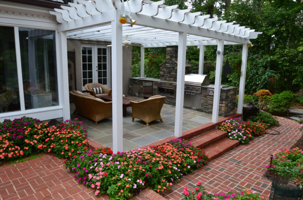 Foto de terraza tradicional renovada de tamaño medio en patio trasero con cocina exterior, suelo de hormigón estampado y pérgola