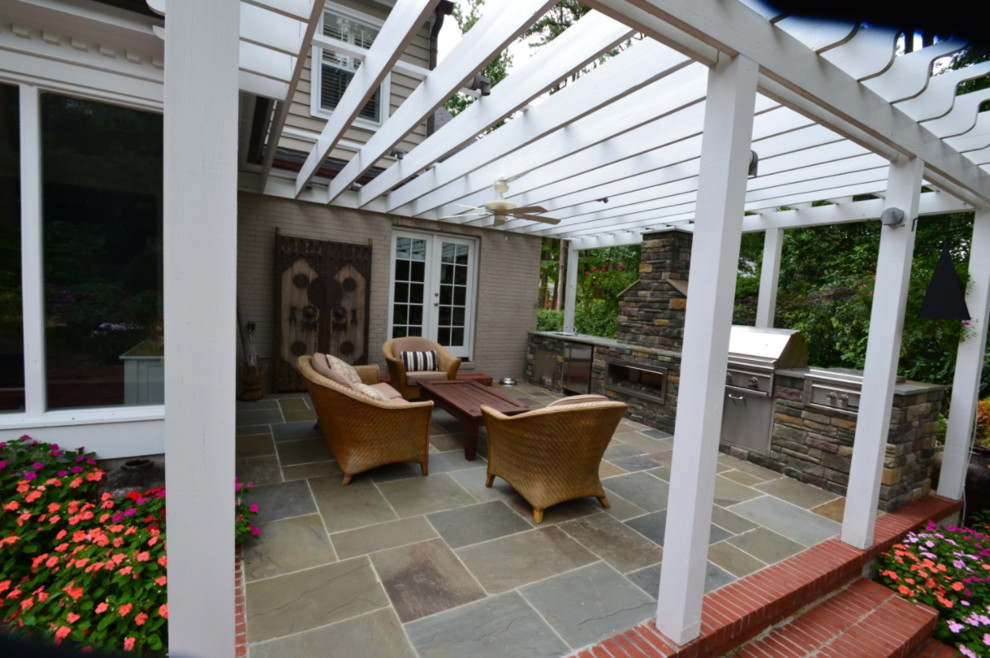 Imagen de terraza tradicional renovada de tamaño medio en patio trasero con cocina exterior, suelo de hormigón estampado y pérgola