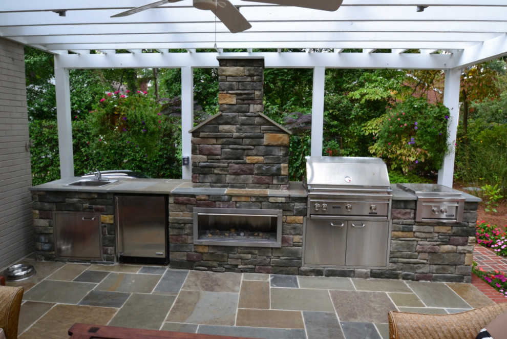 Réalisation d'une terrasse arrière tradition de taille moyenne avec une cuisine d'été, du béton estampé et une pergola.